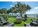 This backyard features a serene lake view, a cozy fire pit, and well-manicured artificial turf at 15787 Tangerine Dream Ct, Winter Garden, FL 34787