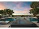 Luxury pool and spa featuring mosaic tiling, set against a serene lake backdrop with mature trees and wrought iron fencing at 15787 Tangerine Dream Ct, Winter Garden, FL 34787