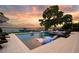 Beautiful pool featuring lounge chairs partially submerged in shallow water and view of the lake at sunset at 15787 Tangerine Dream Ct, Winter Garden, FL 34787
