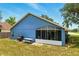 Backyard view of the home featuring a screened-in lanai, grill, and picnic table at 171 Cedarpark Ln, Davenport, FL 33837