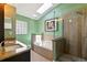 Bathroom featuring a tub with tiled walls, glass enclosed shower, and granite countertop vanity at 171 Cedarpark Ln, Davenport, FL 33837