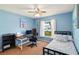 A blue guest bedroom featuring a desk with computer, ceiling fan, and view to front yard at 171 Cedarpark Ln, Davenport, FL 33837