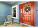 Inviting front entrance with a red door, wreath, and a cozy seating area for welcoming guests at 171 Cedarpark Ln, Davenport, FL 33837