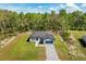 Aerial view of a single-story home with a paved driveway and large trees around the property at 17445 Sw 41St Cir, Ocala, FL 34473