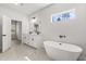 Modern bathroom with double vanity, sleek fixtures, freestanding tub, and natural light from a window at 17445 Sw 41St Cir, Ocala, FL 34473