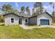 Well-kept single-story home featuring a blue garage door and a lush green front lawn at 17445 Sw 41St Cir, Ocala, FL 34473