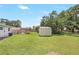 Expansive backyard featuring a lawn, a shed, and surrounding trees at 214 S Cottage Hill Rd, Orlando, FL 32805