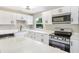 Bright kitchen with white cabinets, quartz countertops, and stainless steel appliances at 214 S Cottage Hill Rd, Orlando, FL 32805