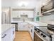 Well-lit kitchen featuring sleek white cabinets, quartz countertops, and stainless steel appliances at 214 S Cottage Hill Rd, Orlando, FL 32805