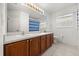 Bathroom with double sink vanity, a large mirror, and tile flooring at 2512 Chapala Dr, Kissimmee, FL 34746