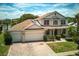Aerial view of two-story home with three-car garage, landscaping, and blue sky background at 2512 Chapala Dr, Kissimmee, FL 34746
