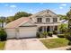 Spacious two-story home with a three-car garage, landscaped front yard, and inviting entryway at 2512 Chapala Dr, Kissimmee, FL 34746