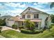 Charming two-story home featuring a well-maintained lawn, lush landscaping, and a brick-paved driveway at 2512 Chapala Dr, Kissimmee, FL 34746
