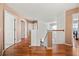 Upstairs hallway with wood-look floors, open stairway, and doorways leading to bedrooms at 2512 Chapala Dr, Kissimmee, FL 34746