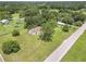 Aerial view showcases a vast lawn with mature trees surrounding this home at 28 N Osceola Ave, Center Hill, FL 33514