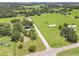 Aerial view of the property with large grassy land and mature trees at 28 N Osceola Ave, Center Hill, FL 33514