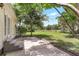 Backyard features a concrete patio with a view of the grassy lawn and mature trees at 28 N Osceola Ave, Center Hill, FL 33514