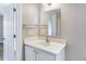 White bathroom vanity with quartz countertop, mirror, and decorative light fixture at 28 N Osceola Ave, Center Hill, FL 33514