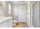 Bright bathroom with a white vanity, a toilet and a shower with sliding doors at 28 N Osceola Ave, Center Hill, FL 33514