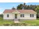 Charming yellow home featuring a covered porch, sidewalk, and mature landscaping at 28 N Osceola Ave, Center Hill, FL 33514