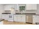 Clean kitchen featuring white appliances, wood flooring, and practical kitchen layout at 28 N Osceola Ave, Center Hill, FL 33514
