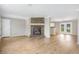 Open-concept living room with a brick fireplace and hardwood flooring flowing into the kitchen at 28 N Osceola Ave, Center Hill, FL 33514