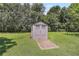 Backyard storage building in a serene backyard with a concrete walkway at 28 N Osceola Ave, Center Hill, FL 33514