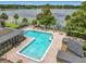 Community pool with an open deck and lounge chairs overlooking a tranquil lake, perfect for relaxation at 305 West Lake Faith Dr # 139, Maitland, FL 32751