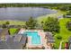 View of the community pool and lake featuring comfortable lounge chairs, tables and manicured lawns at 305 West Lake Faith Dr # 139, Maitland, FL 32751