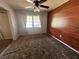 Comfortable bedroom with lots of natural light, wood accent wall, and neutral decor at 3540 Garland St, Mulberry, FL 33860