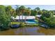 Aerial view of the home with a dock on the canal and a small backyard pool at 418 Acacia Cir, Port Orange, FL 32127