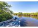Dock with a boat sitting on the calm and inviting river, surrounded by lush mangroves at 418 Acacia Cir, Port Orange, FL 32127