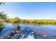 Dock with a boat sitting on the calm and inviting river, surrounded by lush mangroves at 418 Acacia Cir, Port Orange, FL 32127
