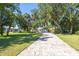 Paver driveway leading to a charming single-story home with lush landscaping and beautiful curb appeal at 418 Acacia Cir, Port Orange, FL 32127
