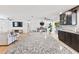 Open concept kitchen with granite island seamlessly connects to a living room with modern decor and entertainment center at 418 Acacia Cir, Port Orange, FL 32127
