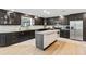 Modern kitchen features dark cabinetry, stainless appliances, granite counters and island with brick accents at 418 Acacia Cir, Port Orange, FL 32127