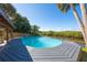 A swimming pool with a backyard view, surrounded by trees and a canal at 418 Acacia Cir, Port Orange, FL 32127
