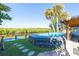 A small pool surrounded by a deck, with the canal right behind it, and the house to the side at 418 Acacia Cir, Port Orange, FL 32127