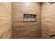 Close up of shower with wood-look tiled walls and custom tiled shelving at 418 Acacia Cir, Port Orange, FL 32127
