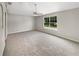 Generously sized bedroom with neutral carpeting, a ceiling fan, and a large window offering scenic views at 4209 Sw 33Rd St, Ocala, FL 34474