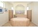 Bright bathroom showcasing a tiled tub with glass block detail and natural light from a window at 436 Skyview Pl, Chuluota, FL 32766