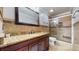 Bathroom with granite countertop, dark wood cabinets, and a walk-in shower with a glass door at 447 Kehoe Blvd, Orlando, FL 32825