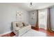 Cozy bedroom featuring a white leather love seat, hardwood floors and white walls and natural light at 447 Kehoe Blvd, Orlando, FL 32825