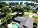Aerial shot featuring a private backyard pool and the surrounding community near a tranquil lake at 5096 The Oaks Cir, Orlando, FL 32809