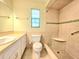 Bathroom with tiled shower, a window for natural light, and neutral color palette at 5096 The Oaks Cir, Orlando, FL 32809