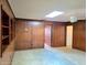 Bedroom features wood-paneled walls, a ceiling fan, carpet flooring and built-in shelving at 5096 The Oaks Cir, Orlando, FL 32809