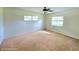Empty bedroom with carpet, neutral walls, ceiling fan, and a large window with natural light at 5096 The Oaks Cir, Orlando, FL 32809