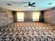 The expansive bonus room has panel walls, carpet, and large windows, creating a versatile living space at 5096 The Oaks Cir, Orlando, FL 32809
