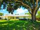 Charming single-story home featuring a well-manicured lawn, mature trees, and a classic facade with a cozy entryway at 5096 The Oaks Cir, Orlando, FL 32809
