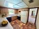 Cozy kitchen with vintage tile floor, light wood cabinets and a white refrigerator at 5096 The Oaks Cir, Orlando, FL 32809